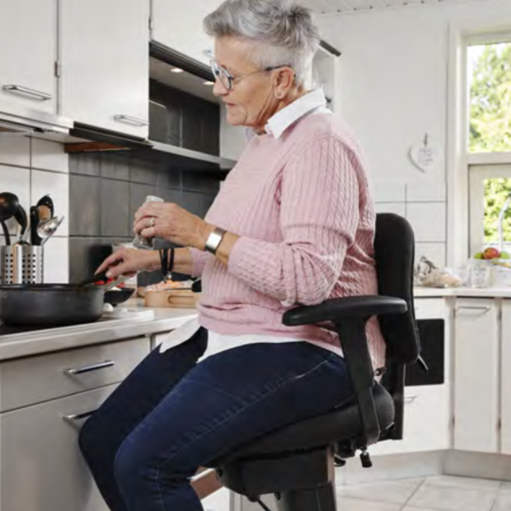 persona mayor cocinando con silla ergonómica